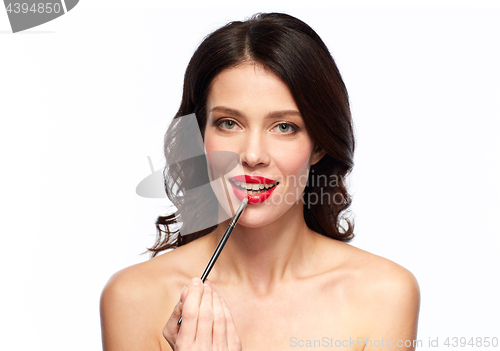 Image of beautiful woman with make up brush for lipstick