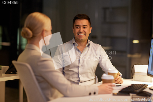 Image of business people drinking coffee at night office