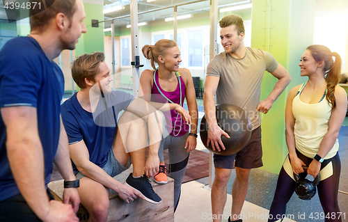 Image of group of friends with sports equipment in gym