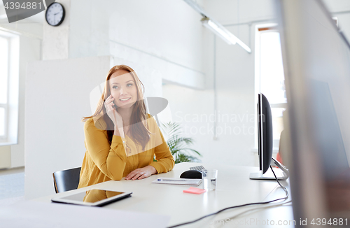 Image of businesswoman calling on smartphone at office