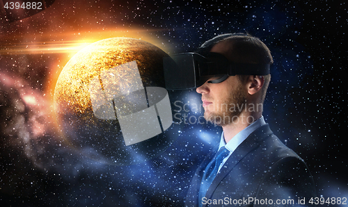 Image of businessman in virtual reality headset over space