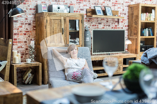 Image of Woman shopping for new rocking chair in furniture store.