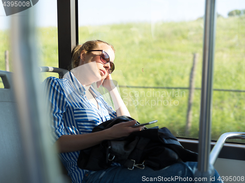 Image of Portrait of tired woman sleeping on bus.