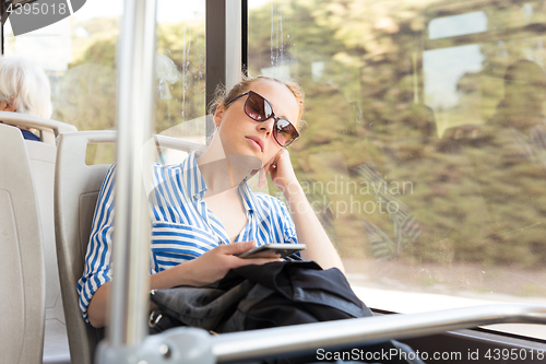 Image of Portrait of tired woman sleeping on bus.