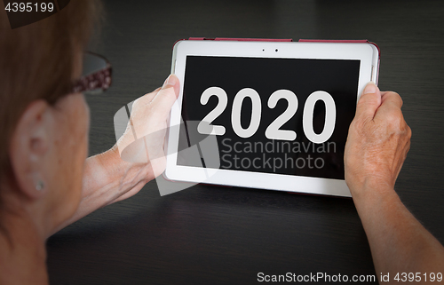 Image of Senior lady relaxing and her tablet - 2020