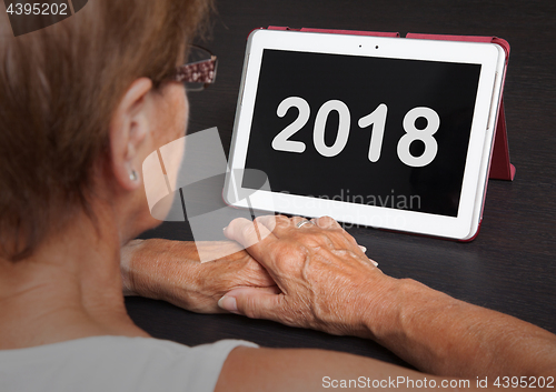 Image of Senior lady relaxing and her tablet - 2018