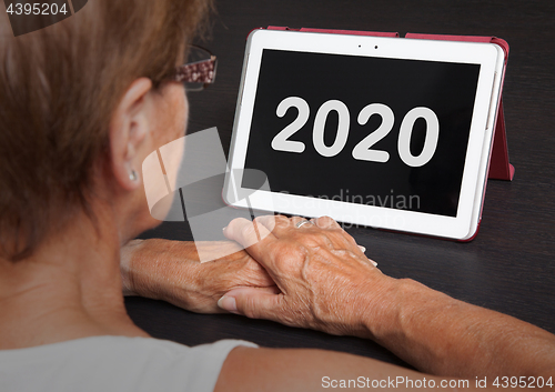 Image of Senior lady relaxing and her tablet - 2020