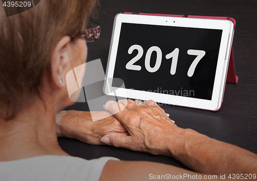 Image of Senior lady relaxing and her tablet - 2017