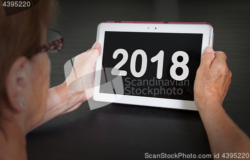 Image of Senior lady relaxing and her tablet - 2018