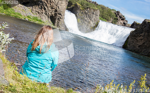 Image of Woman sitting at a waterfall