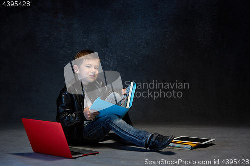 Image of Little boy sitting with gadgets