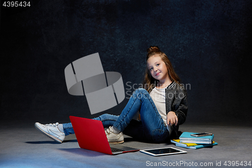 Image of Little girl sitting with gadgets