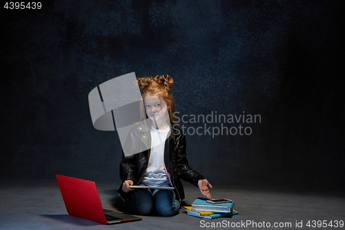 Image of Little girl sitting with gadgets