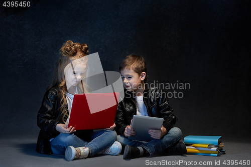 Image of Studio shot of two children with laptop