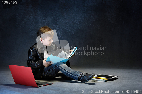 Image of Little boy sitting with gadgets