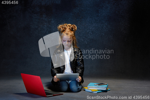 Image of Little girl sitting with gadgets