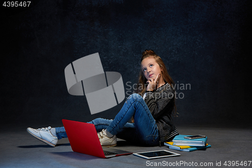 Image of Little girl sitting with gadgets