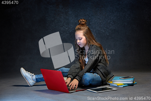 Image of Little girl sitting with gadgets