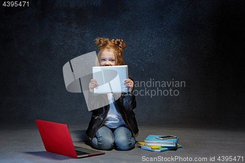 Image of Little girl sitting with gadgets