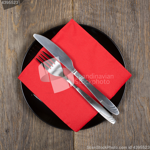 Image of Plate, knfie and fork on a napkin.