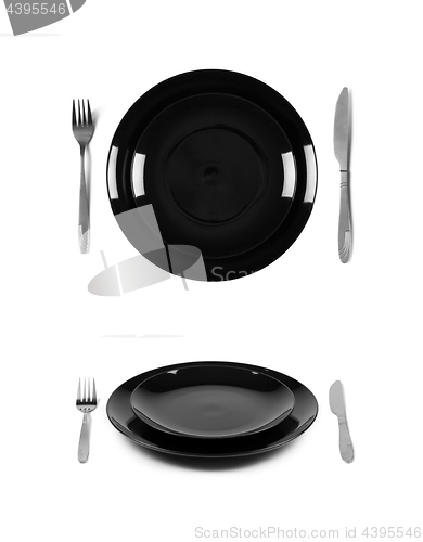 Image of Two black plates with fork and knife