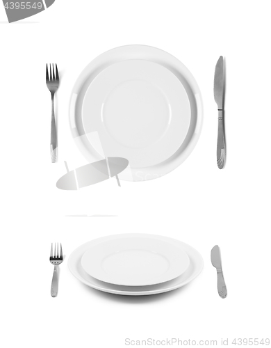 Image of Two white plates with fork and knife