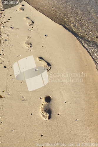 Image of Nature background with sea water and footprints in the sand 