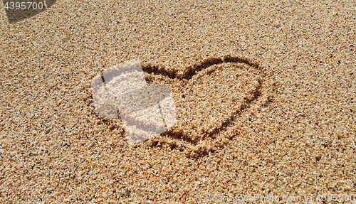 Image of Drawing of abstract heart in the sand background