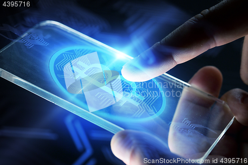 Image of close up of hands with smartphone and bitcoin