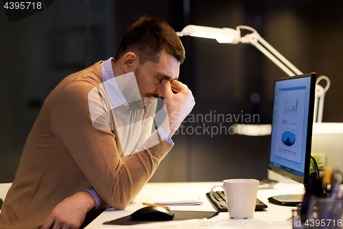 Image of tired businessman working at night office