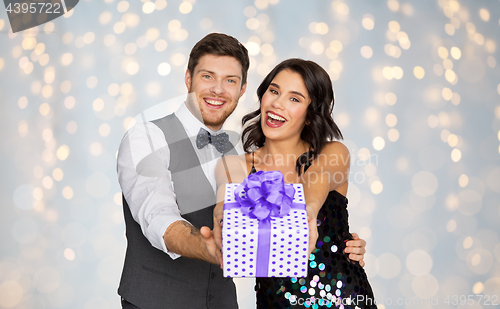 Image of happy couple with gift box at birthday party