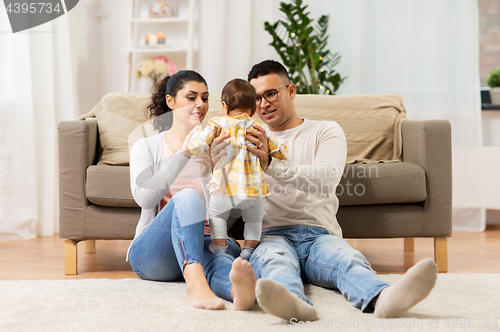 Image of happy family with baby daughter at home