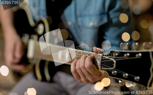 Image of close up of man playing guitar at studio rehearsal