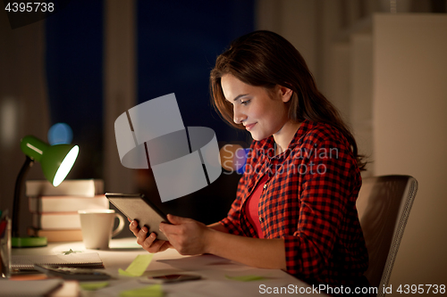 Image of student girl or woman with tablet pc at night home