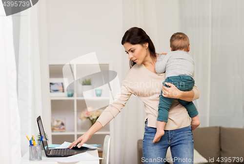 Image of mother with baby and laptop working at home