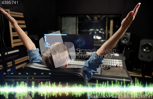 Image of man at mixing console in music recording studio