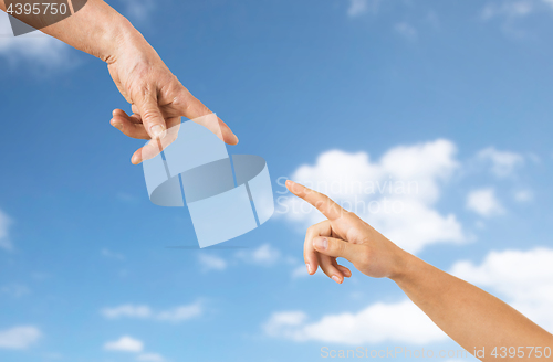 Image of close up of senior and young woman hands