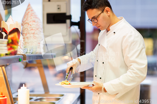 Image of chef with salad on plate at fast food restaurant