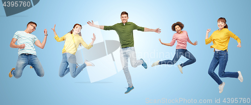 Image of happy people or friends jumping in air over blue