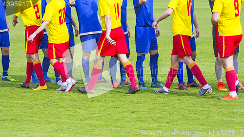 Image of Two soccer team handshake on field before the football game