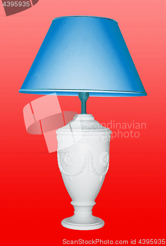 Image of Vintage table lamp iwith a blue eyeshadow on red background