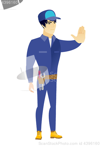 Image of Asian mechanic showing stop hand gesture.