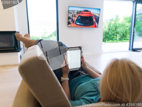 Image of woman on sofa using tablet computer