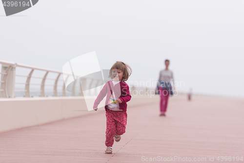 Image of mother and cute little girl on the promenade by the sea