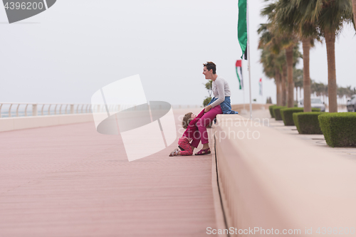 Image of mother and cute little girl on the promenade by the sea