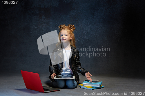 Image of Little girl sitting with gadgets