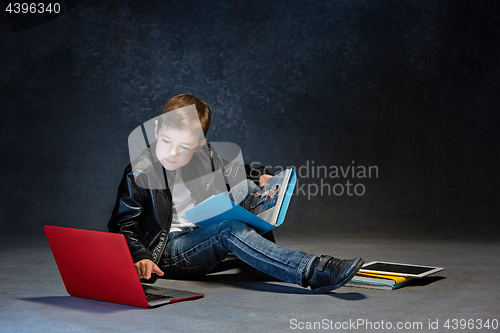 Image of Little boy sitting with gadgets