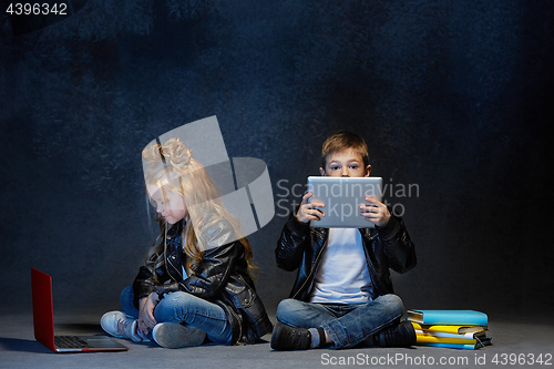 Image of Studio shot of two children with laptop