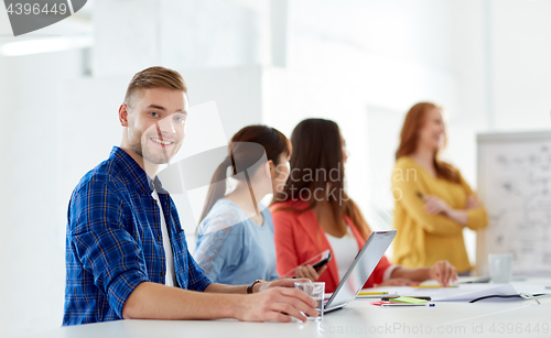 Image of happy man with creative team at office conference