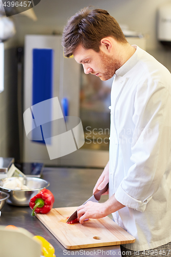 Image of happy male chef cooking food at restaurant kitchen